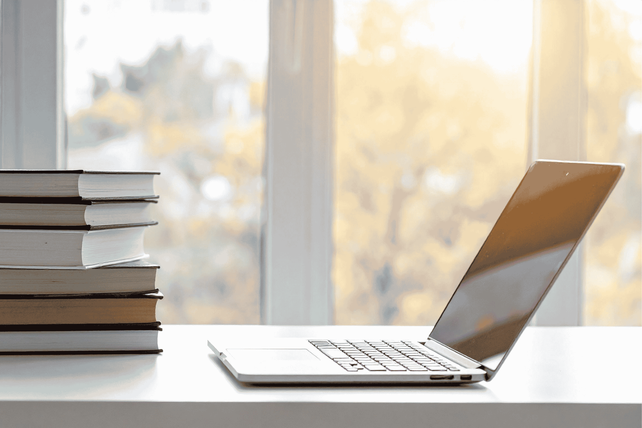 open-laptop-with-books-on-a-desk